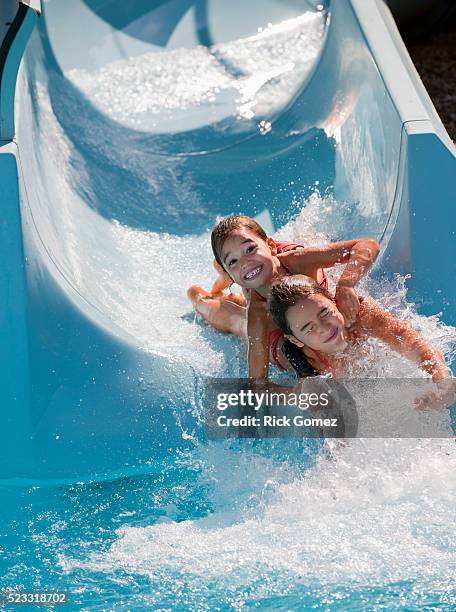 kids sliding down water slide - waterslide stock pictures, royalty-free photos & images