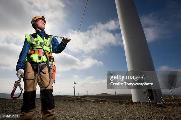 windfarm technician servicing turbines - harnais de sécurité photos et images de collection