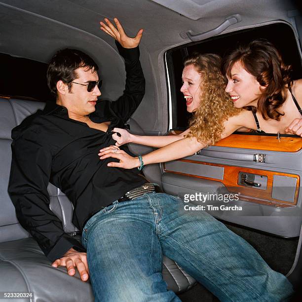 young women grabbing young man through limousine window - groupie stock pictures, royalty-free photos & images