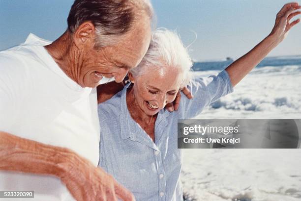 senior couple on the beach - older couple hugging on beach stock pictures, royalty-free photos & images