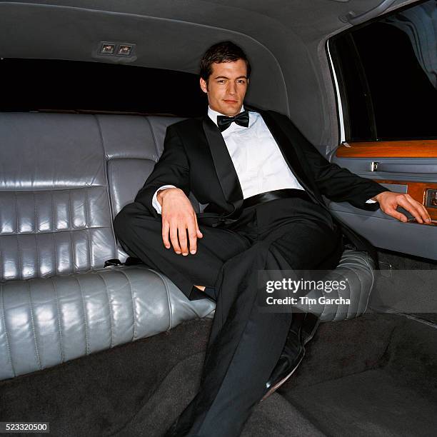 man wearing dinner jacket in the back seat of limousine - smoking photos et images de collection