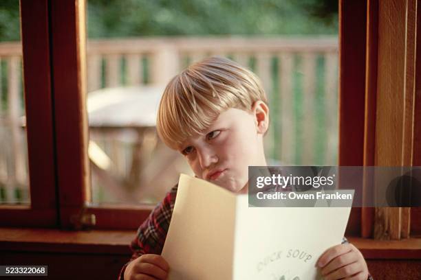 boy making a face while reading a menu - つまらない仕事 ストックフォトと画像