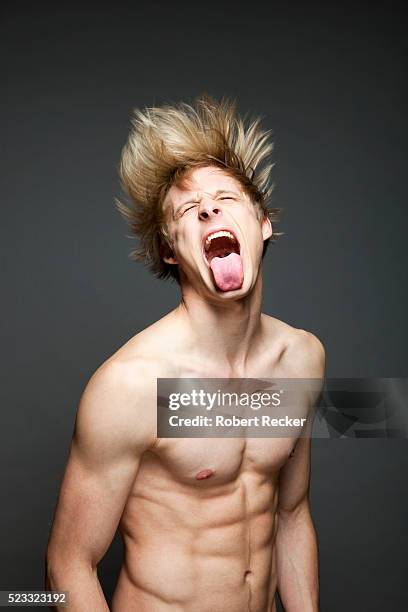 young man sticking out his tongue - man tongue stock pictures, royalty-free photos & images