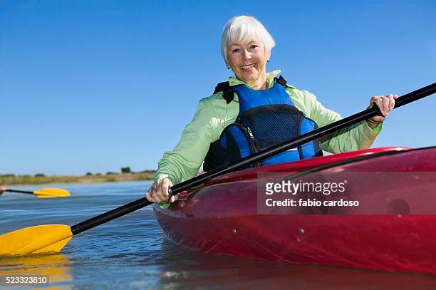 senior woman kayaking - sea kayaking imagens e fotografias de stock