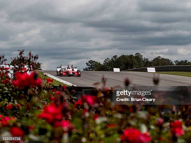 Carlos Munoz, of Colombia, drives the Honda IndyCar past some flowers during practice for the Honda Indy Grand Prix of Alabama at Barber Motorsports...