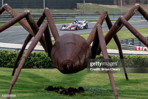 Jack Hawksworth, of England, drives the Honda IndyCar past a spider sculpture during practice for the Honda Indy Grand Prix of Alabama at Barber...