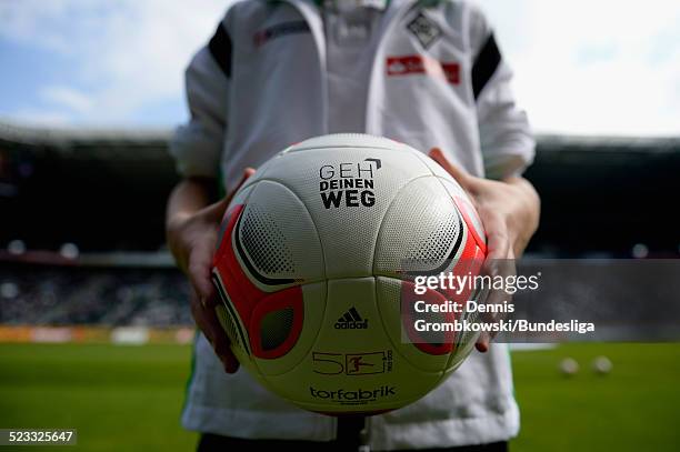 Young child poses with the playball displaying the 'Geh deinen Weg' logo prior to the Bundesliga match between VfL Borussia Moenchengladbach and 1....