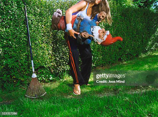 young woman carrying garden gnome - garden gnome stock pictures, royalty-free photos & images