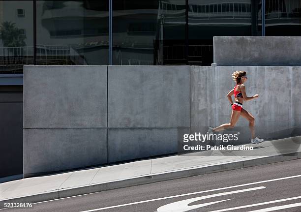 young woman running in the city - hill stock pictures, royalty-free photos & images
