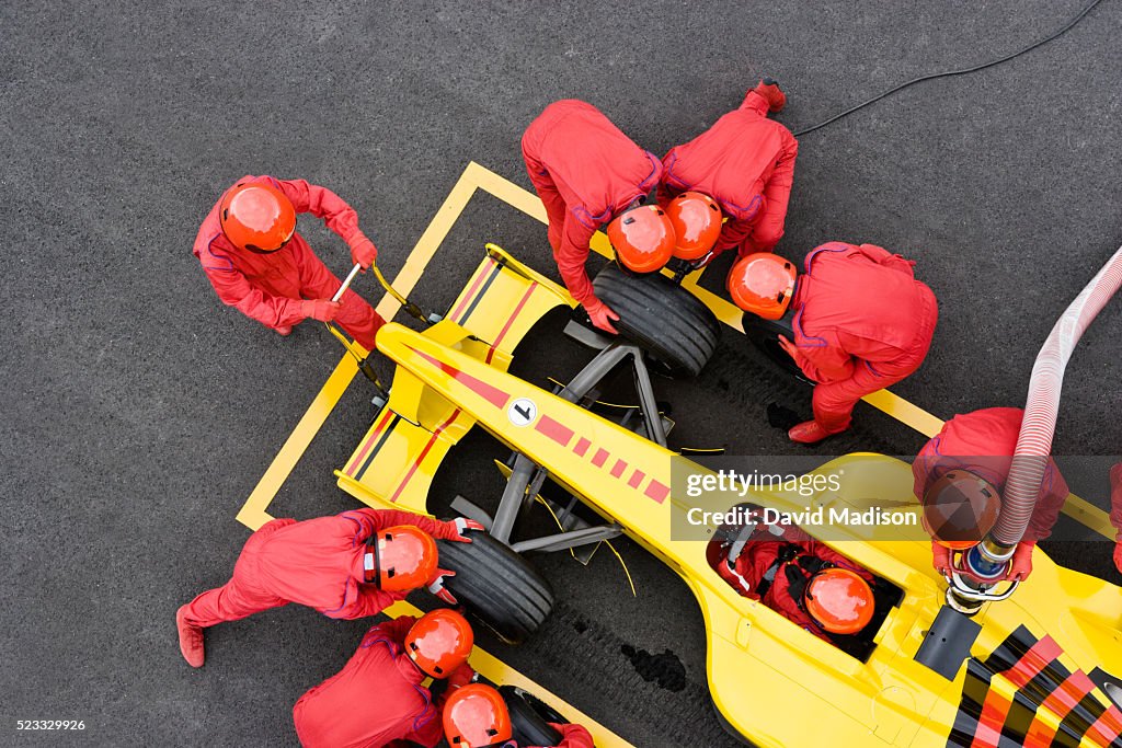 Pit Crew Fueling and Changing Tires on Racecar