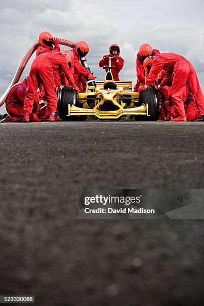 pit crew servicing racecar - pit stop stock pictures, royalty-free photos & images