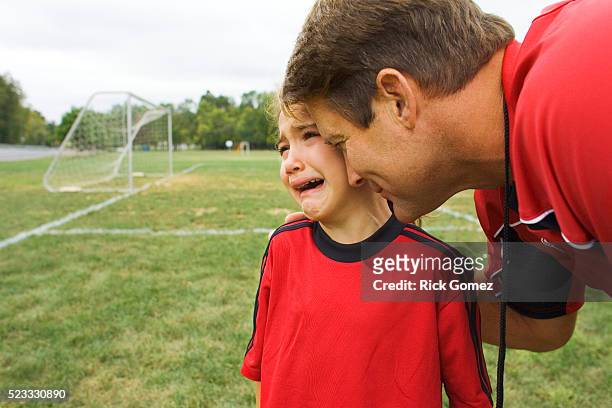soccer coach comforting sad girl - kind child stock pictures, royalty-free photos & images