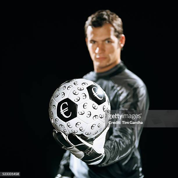 goalkeeper holding soccer ball with euro symbols - bad goalkeeper stock pictures, royalty-free photos & images