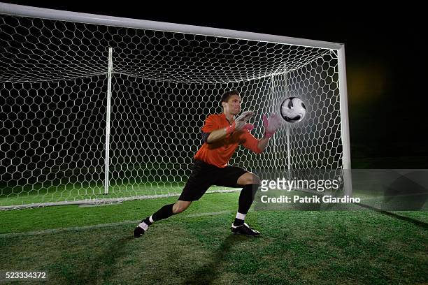 goalkeeper catching soccer ball - catching ball stock pictures, royalty-free photos & images