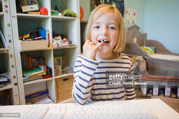 little girl showing a lost tooth on an internet video phone call - tooth fairy stock pictures, royalty-free photos & images