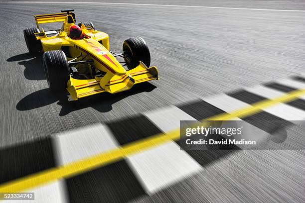 formula one racecar crossing finish line - carrera de coches fotografías e imágenes de stock