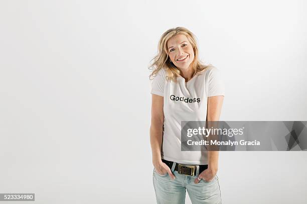 smiling woman wearing 'goddess' t-shirt - 40s woman t shirt studio stock pictures, royalty-free photos & images