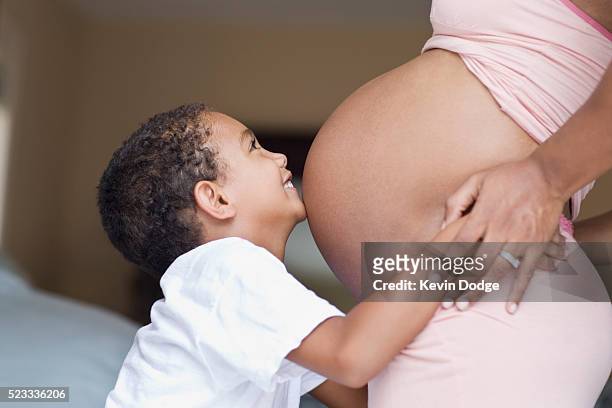 little boy hugging pregnant mother - little kids belly imagens e fotografias de stock