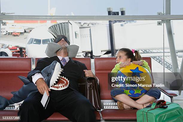 girl watching sleeping businessman in airport - jetlag stock-fotos und bilder