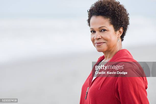 woman standing on a beach - 50 59 years stock pictures, royalty-free photos & images