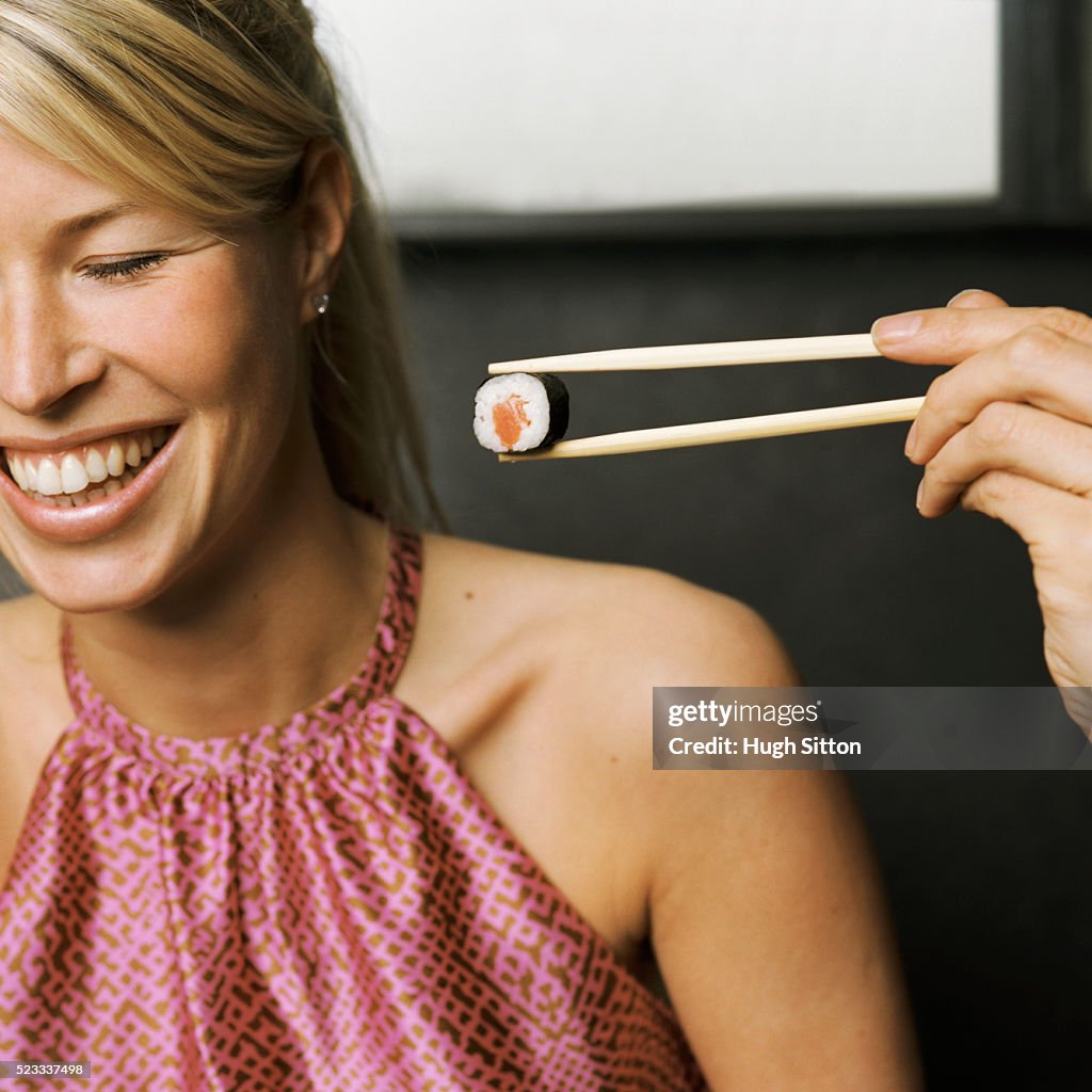 Woman Being Offered Sushi Roll