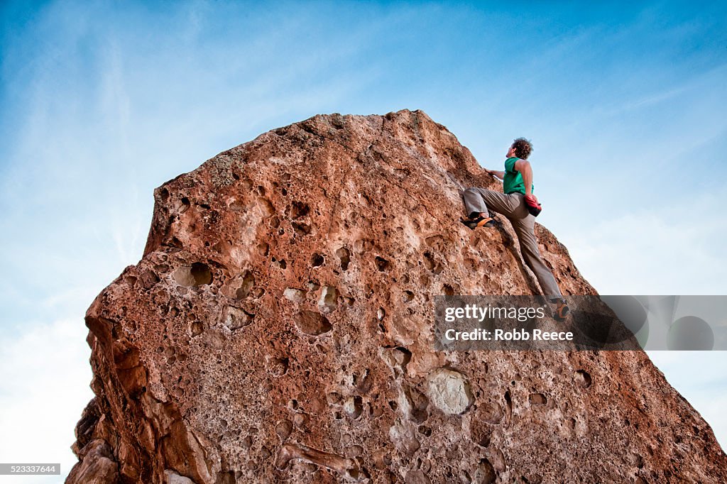 Rock climber climbing boulder