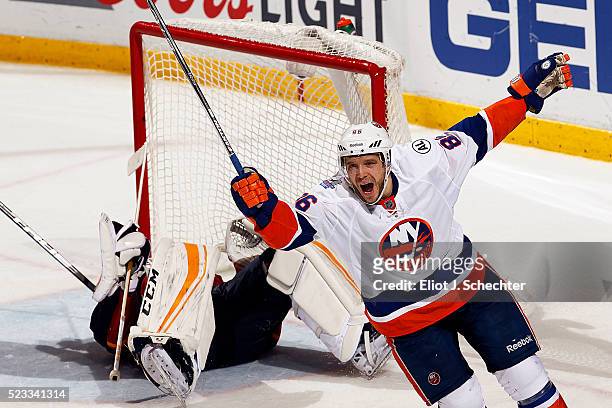 Nikolay Kulemin of the New York Islanders celebrates his teammate Alan Quine scoring the winning goal in the second overtime period against...