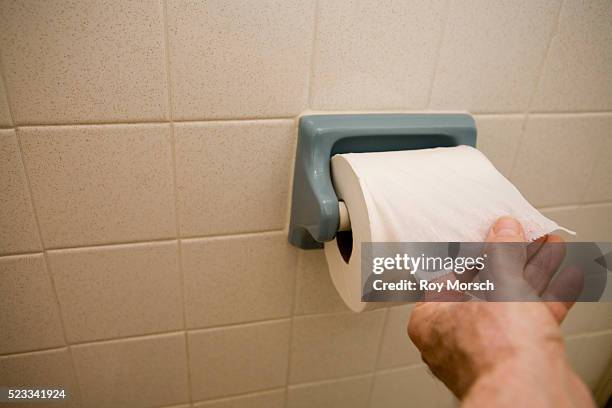 man pulling on toilet paper roll - toilet paper stock pictures, royalty-free photos & images