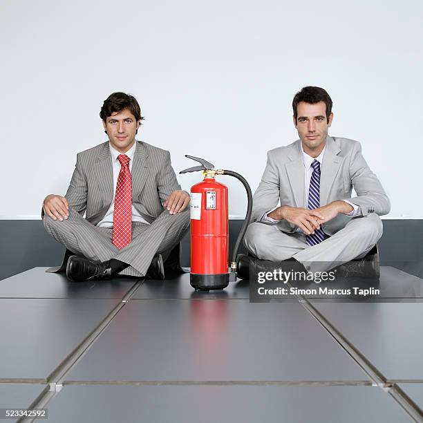 businessmen sitting cross-legged with fire extinguisher - vintage fire extinguisher stock pictures, royalty-free photos & images