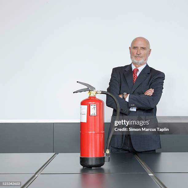 company executive standing with fire extinguisher - vintage fire extinguisher stock pictures, royalty-free photos & images