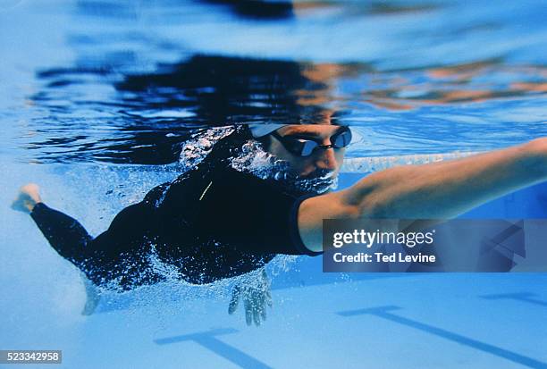 man in wetsuit doing front crawl, barcelona, spain - indoor swimming pool stock pictures, royalty-free photos & images