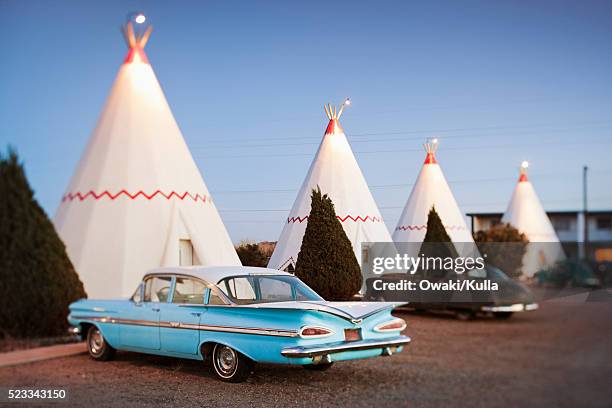 vintage cars parked by wigwam motel rooms - wigwam stock-fotos und bilder