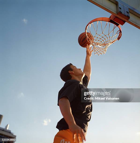 teenager playing basketball - canasta de baloncesto fotografías e imágenes de stock