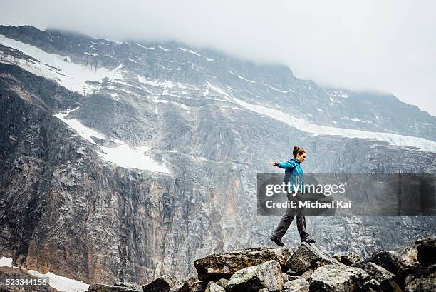 young woman balancing on rocks along angel glacier - jasper stock pictures, royalty-free photos & images
