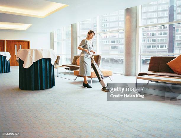 woman vacuuming in conference room - maid stock pictures, royalty-free photos & images