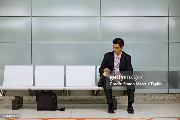 businessman waiting for subway - subway bench bildbanksfoton och bilder