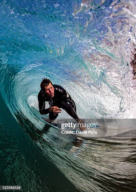 surfer riding through tube wave - surf stockfoto's en -beelden