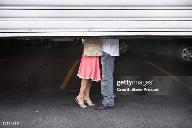 couple kissing behing garage doors - saliente descrição imagens e fotografias de stock