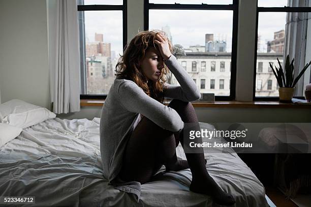 lonely woman in bedroom - depressie stockfoto's en -beelden