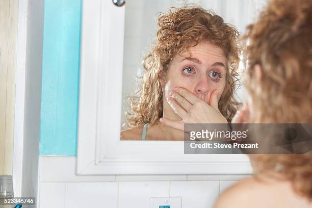 woman examining her eyes - hangover stockfoto's en -beelden