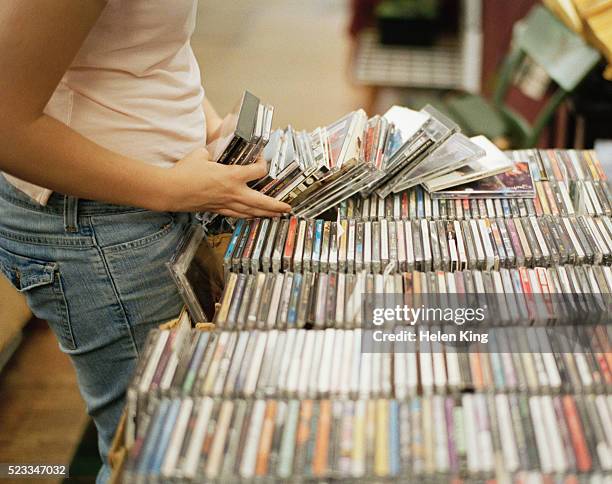 woman going through cds in record store - compact disc fotografías e imágenes de stock
