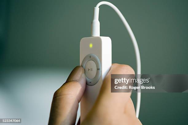 hand holding an mp3 player - mp3 player stock pictures, royalty-free photos & images