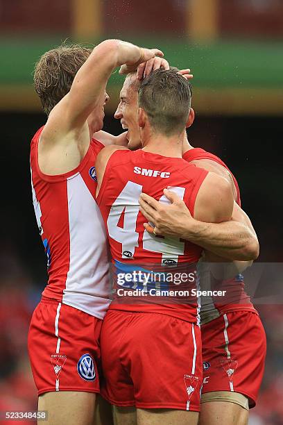 Ted Richards of the Swans celebrates kicking a goal with team mates Jake Lloyd and Callum Mills during the round five AFL match between the Sydney...
