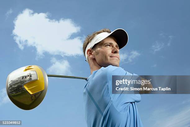 golfer looking at ball after swinging - driver golf club stock pictures, royalty-free photos & images