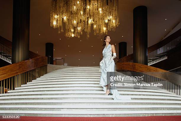 woman descending stairwell - evening gown stock-fotos und bilder
