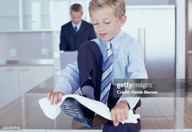 boy dressed as businessman shining his shoes - 靴をみがく ストックフォトと画像