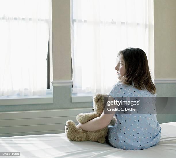 girl on hospital bed holding teddy bear - sad child hospital stock pictures, royalty-free photos & images