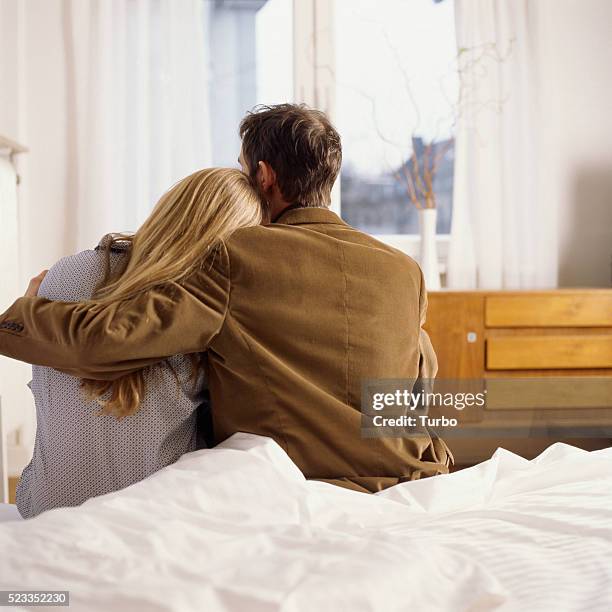 man and woman embracing on bed - couple cuddling in bed stock pictures, royalty-free photos & images