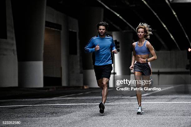 young couple running in the city - street sports ストックフォトと画像