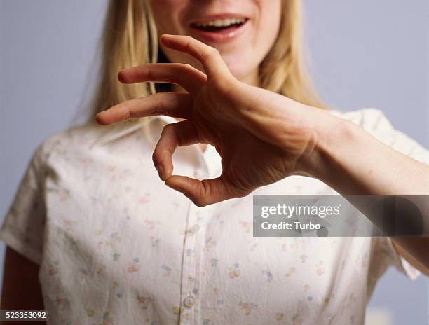 young woman signing "good" - deaf signing stock pictures, royalty-free photos & images